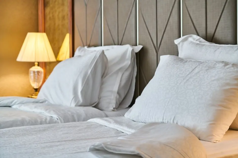Inviting hotel room with comfortable bedding and ambient lighting, perfect for relaxation and luxury stay.